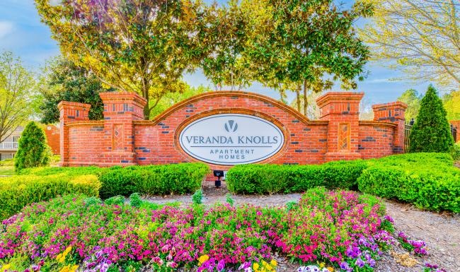 Find your perfect fit at Veranda Knolls a large brick building with a sign in front of it